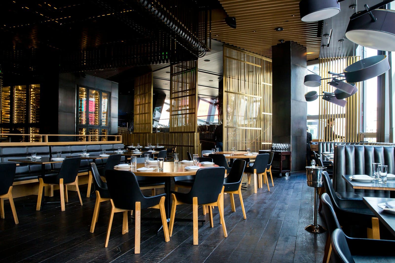 Modern restaurant dining room with set tables and warm wood details
